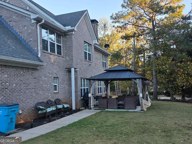 a view of a chair and table in backyard of the house