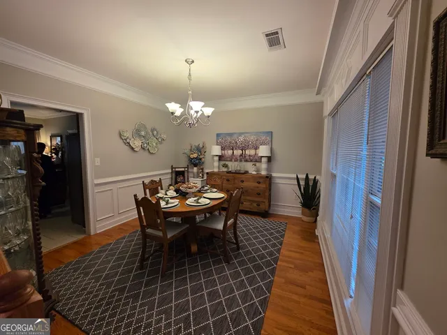a dining room with furniture a rug and wooden floor
