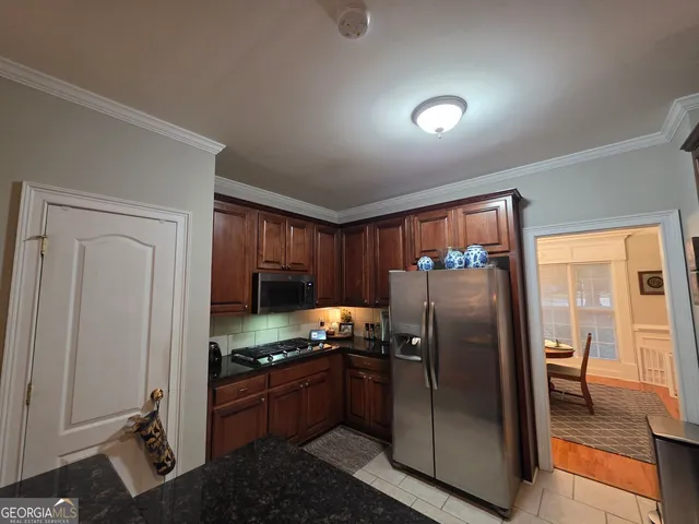 a kitchen with stainless steel appliances granite countertop a refrigerator and a stove