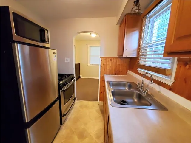 a kitchen with stainless steel appliances granite countertop a refrigerator and a sink