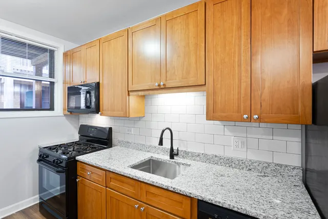 a kitchen with stainless steel appliances granite countertop a sink stove and cabinets