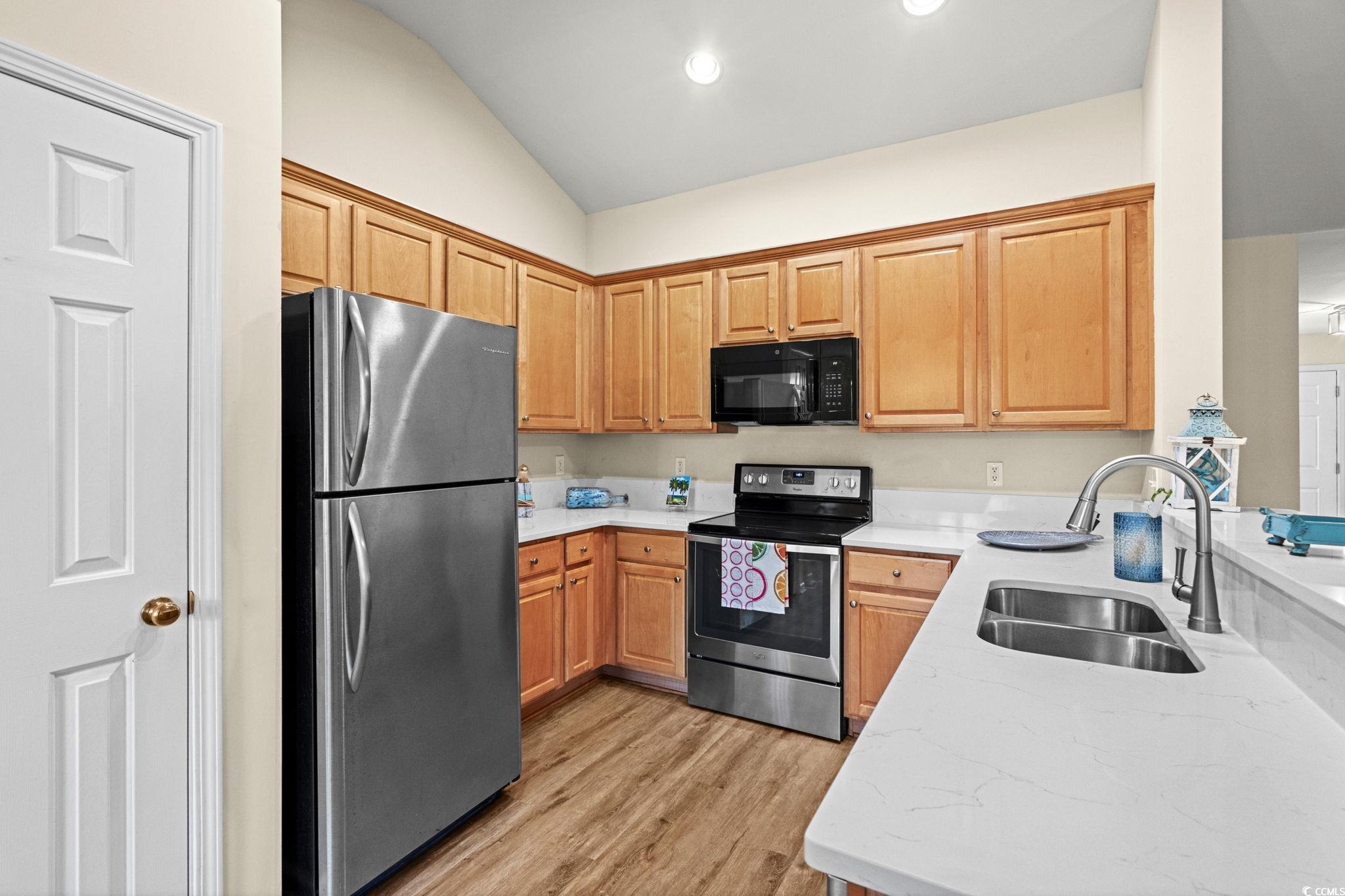 280 Barclay Drive Myrtle Beach, SC 29579 - Photo 17 of 38 Kitchen featuring appliances with stainless steel finishes, light wood-style flooring, light stone counters, vaulted ceiling, and recessed lighting