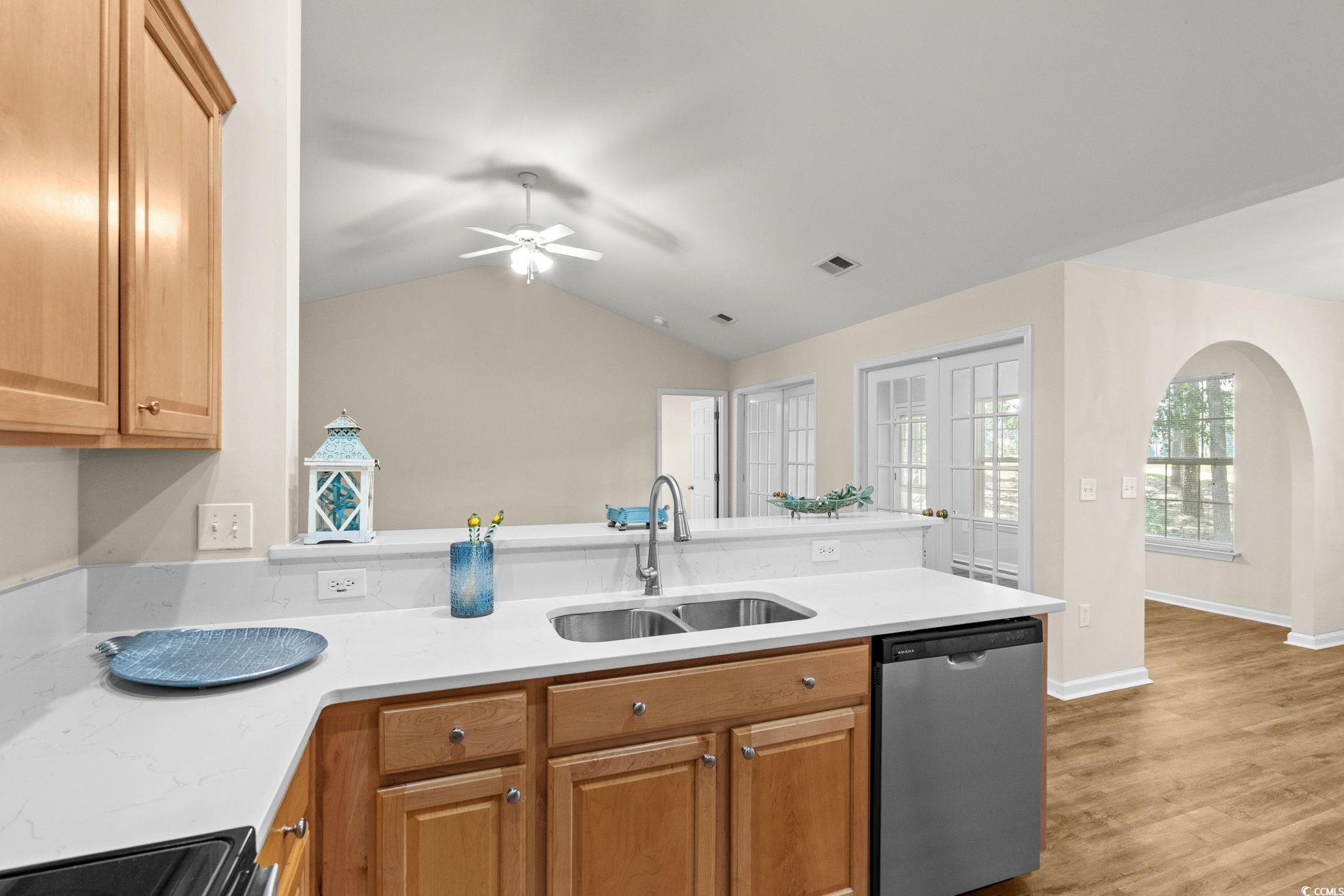 280 Barclay Drive Myrtle Beach, SC 29579 - Photo 18 of 38 Kitchen featuring dishwasher, light stone counters, a peninsula, arched walkways, and brown cabinetry
