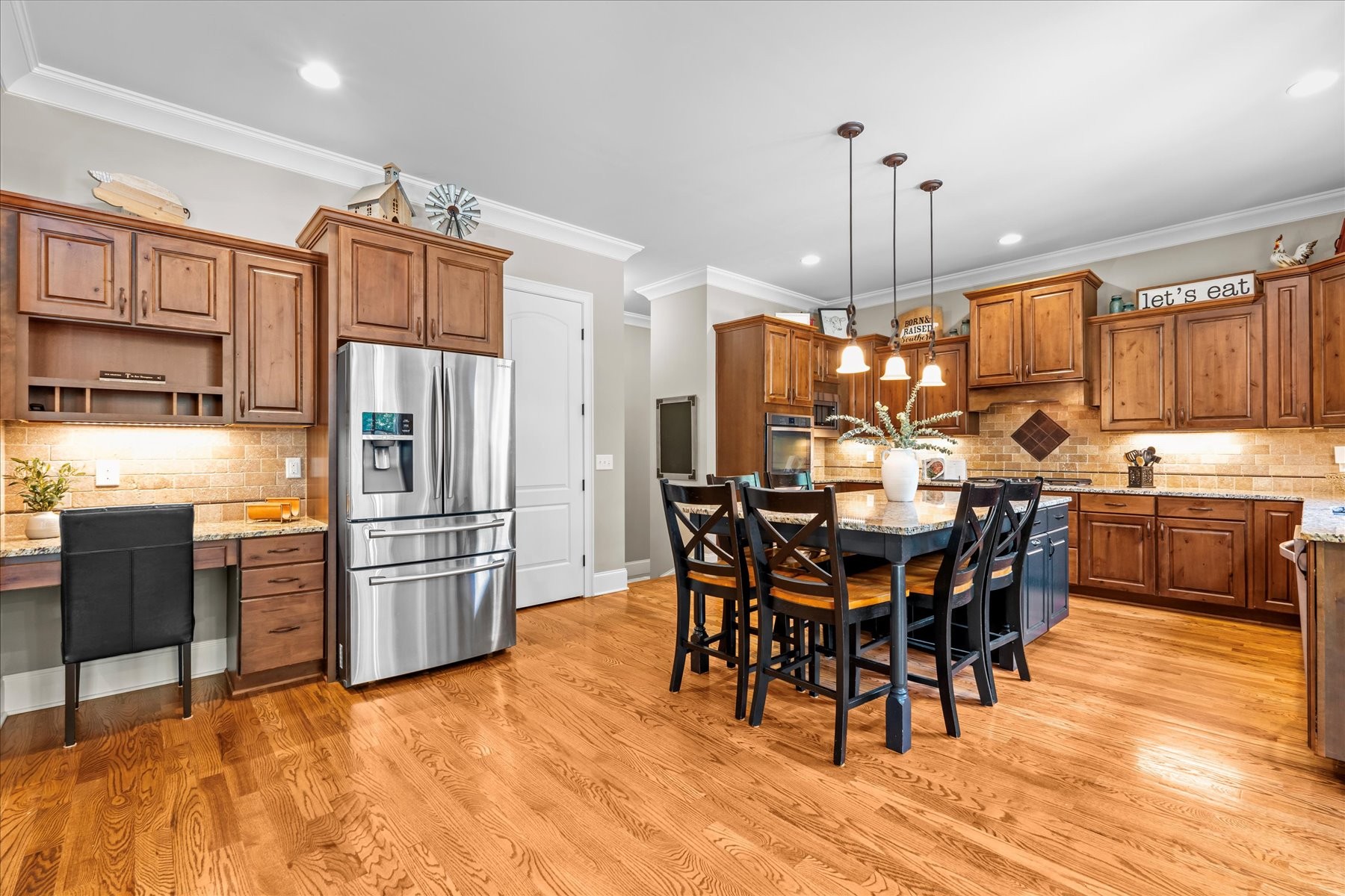 8311 Saundersville Road Mount Juliet, TN 37122 - Photo 27 of 70 a kitchen with stainless steel appliances kitchen island granite countertop a refrigerator a stove a sink a dining table and chairs with wooden floor