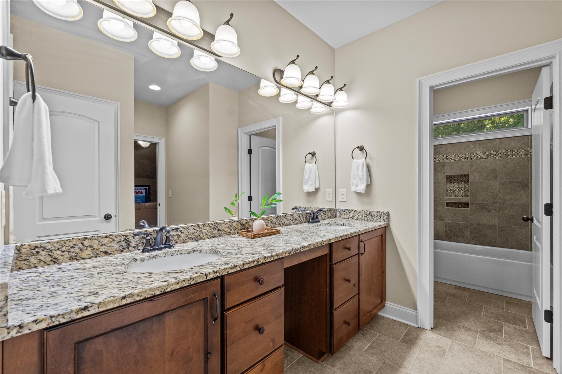 8311 Saundersville Road Mount Juliet, TN 37122 - Photo 59 of 70 a bathroom with a granite countertop sink a large mirror and a bathtub
