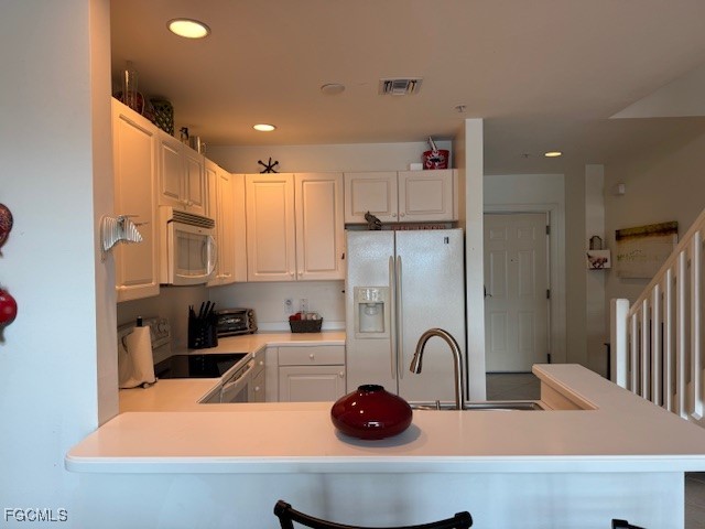 2743 First Street, Unit 104 Fort Myers, FL 33916 - Photo 23 of 32 a kitchen with stainless steel appliances granite countertop a sink a refrigerator and a stove top oven with white countertops