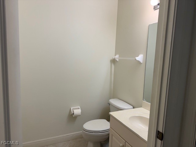 2743 First Street, Unit 104 Fort Myers, FL 33916 - Photo 7 of 32 a white toilet sitting next to a bathroom sink and vanity