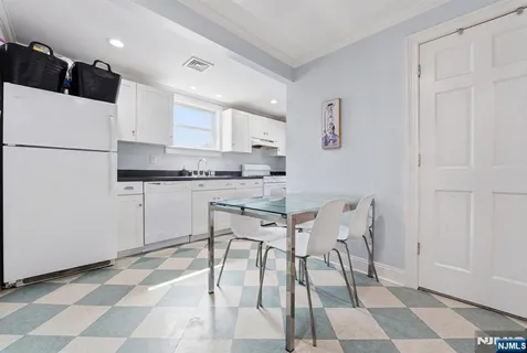a kitchen with stainless steel appliances a refrigerator a stove a sink and white cabinets