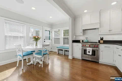 a kitchen with stainless steel appliances white cabinets and wooden floor