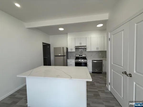 a kitchen with stainless steel appliances a refrigerator and a stove top oven