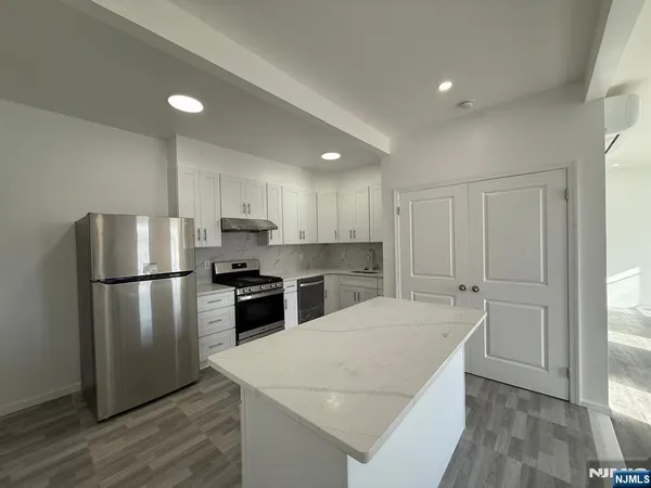 a kitchen with a refrigerator a sink and a stove top oven