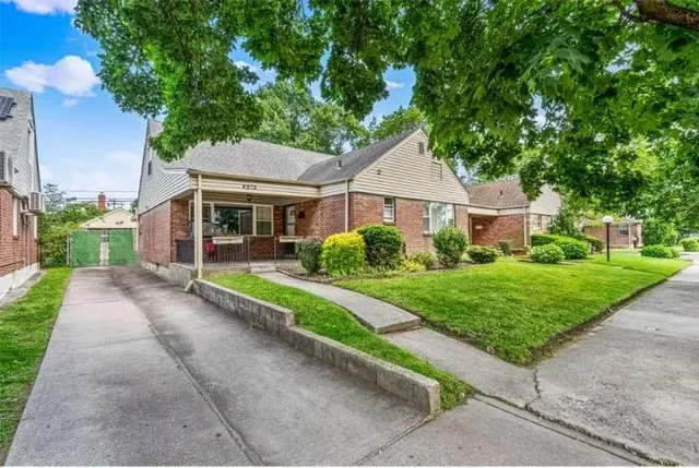 a view of house with a yard and potted plants