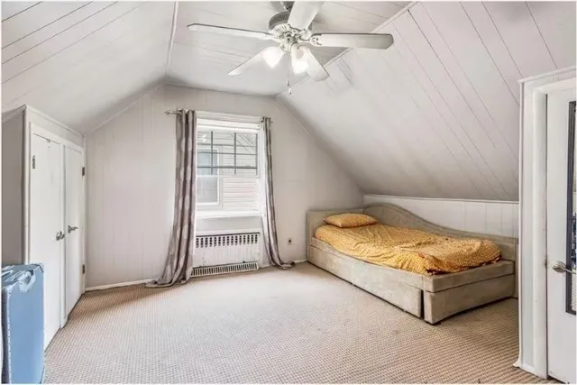 a spacious bedroom with a bed and a ceiling fan