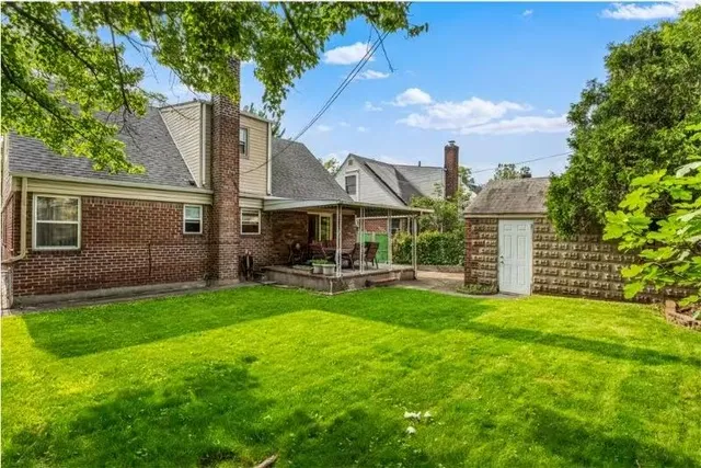 a view of a house with backyard and sitting area