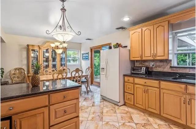 a kitchen with sink refrigerator and window
