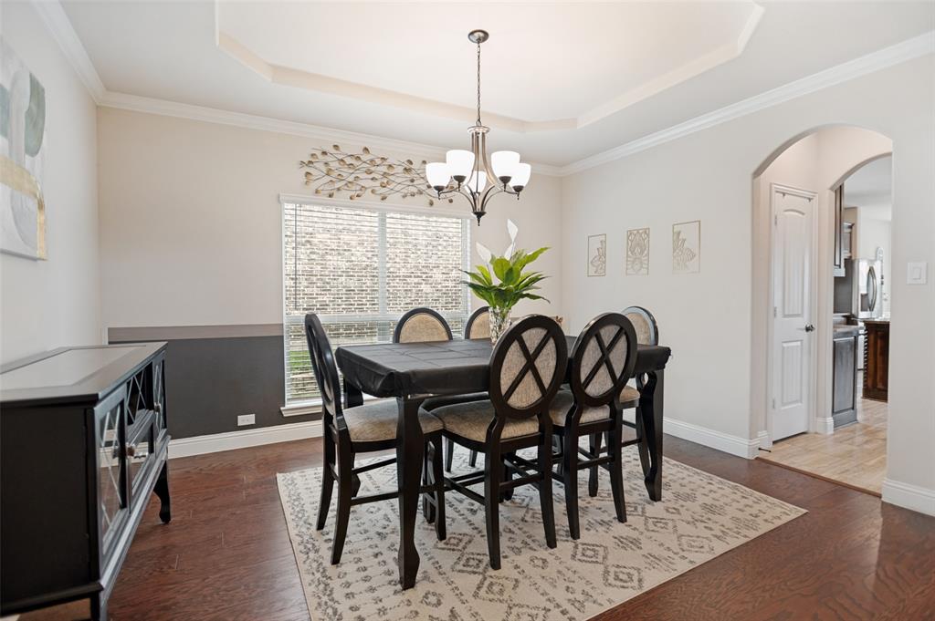 413 Frontier Court Midlothian, TX 76065 - Photo 4 of 26 Formal dining area featuring wood-finish flooring, a tray ceiling, and a chandelier