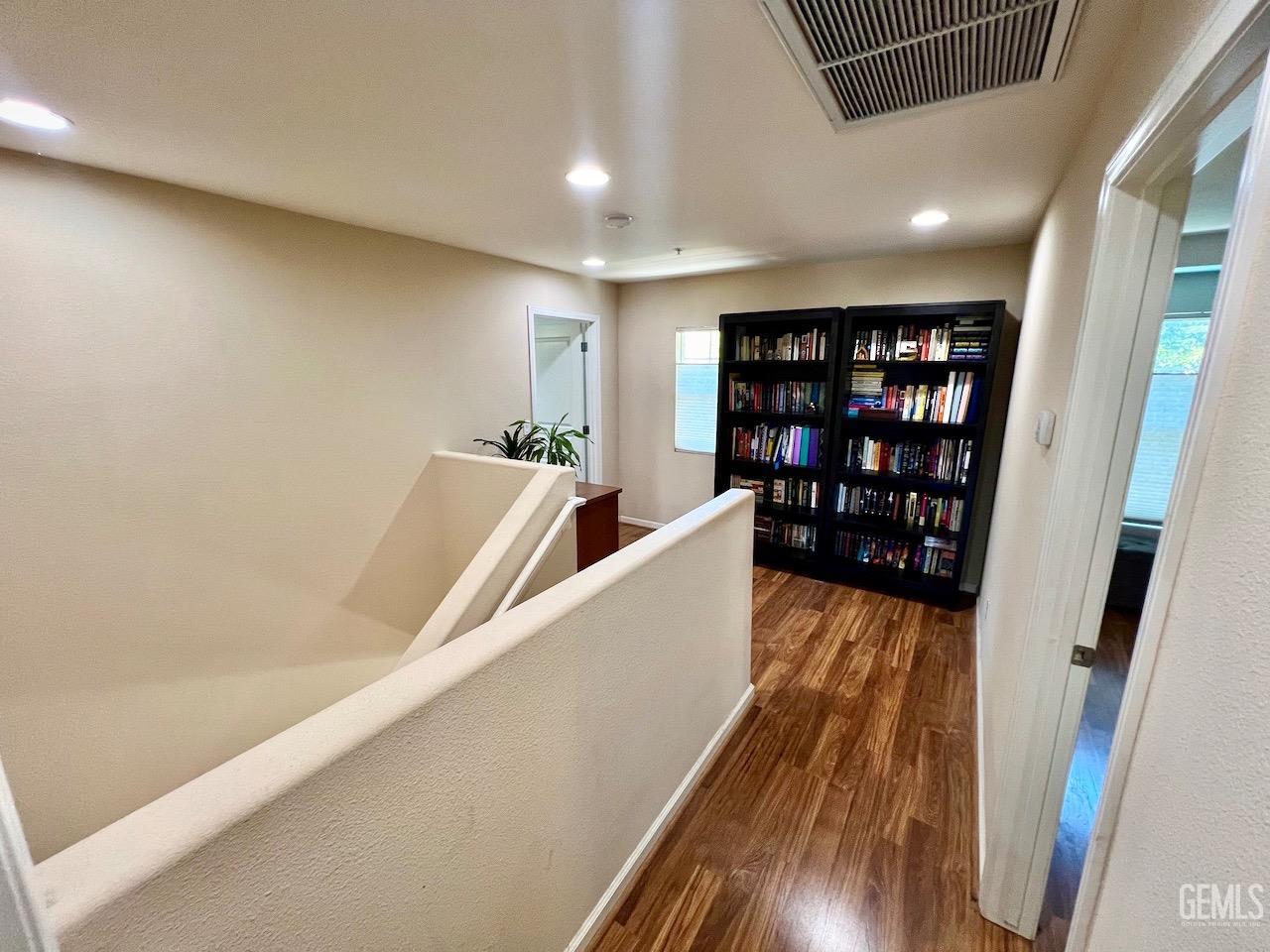 Undisclosed Address Atascadero, CA 93422 - Photo 13 of 30 a hallway with wooden floor and book shelf