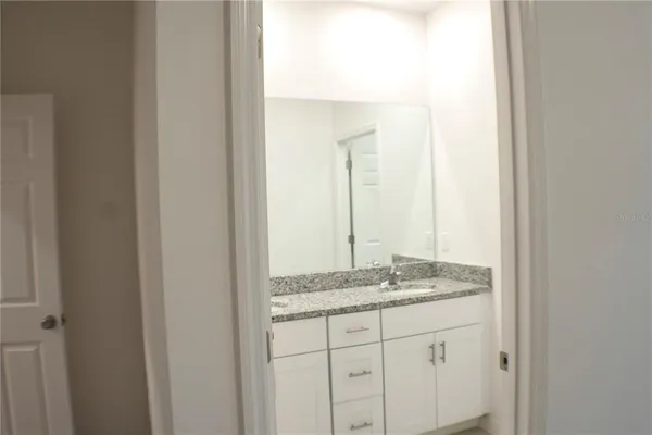 a bathroom with a granite countertop sink and a mirror