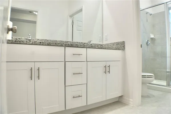 a bathroom with a granite countertop shower and a sink