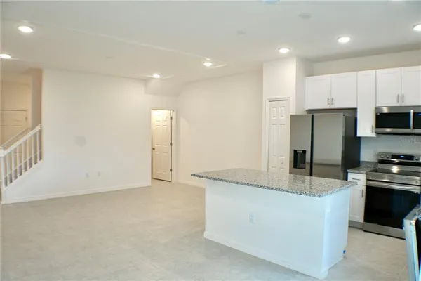 a kitchen with stainless steel appliances granite countertop a refrigerator and a stove
