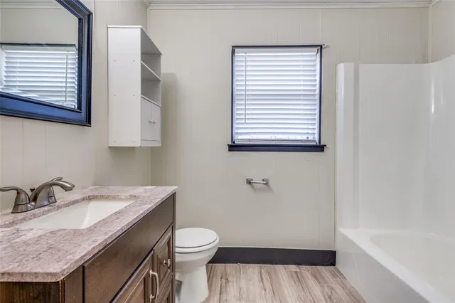 a bathroom with a granite countertop sink toilet and a bathtub