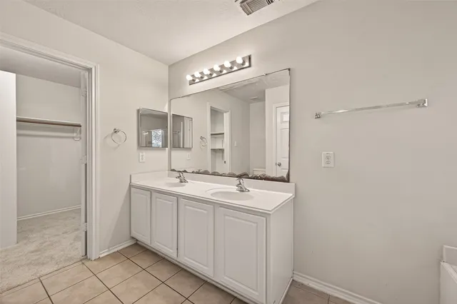 a spacious bathroom with a mirror a sink and a mirror