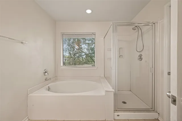 a bathroom with a tub shower vanity and a sink