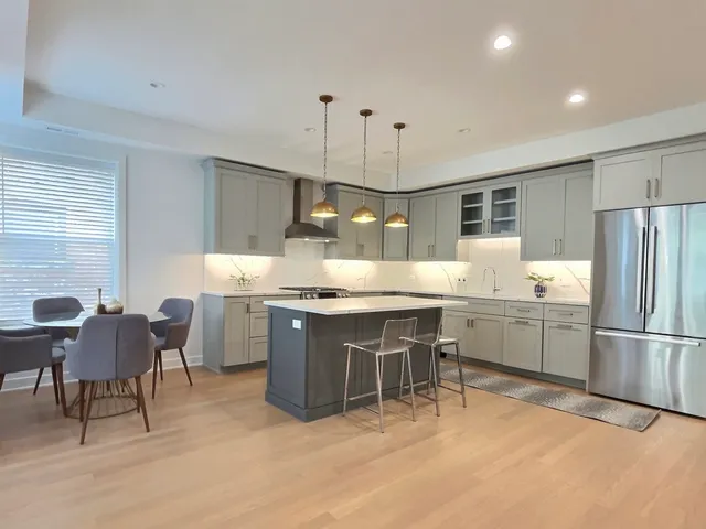 a large kitchen with kitchen island a sink a stove a dining table and chairs
