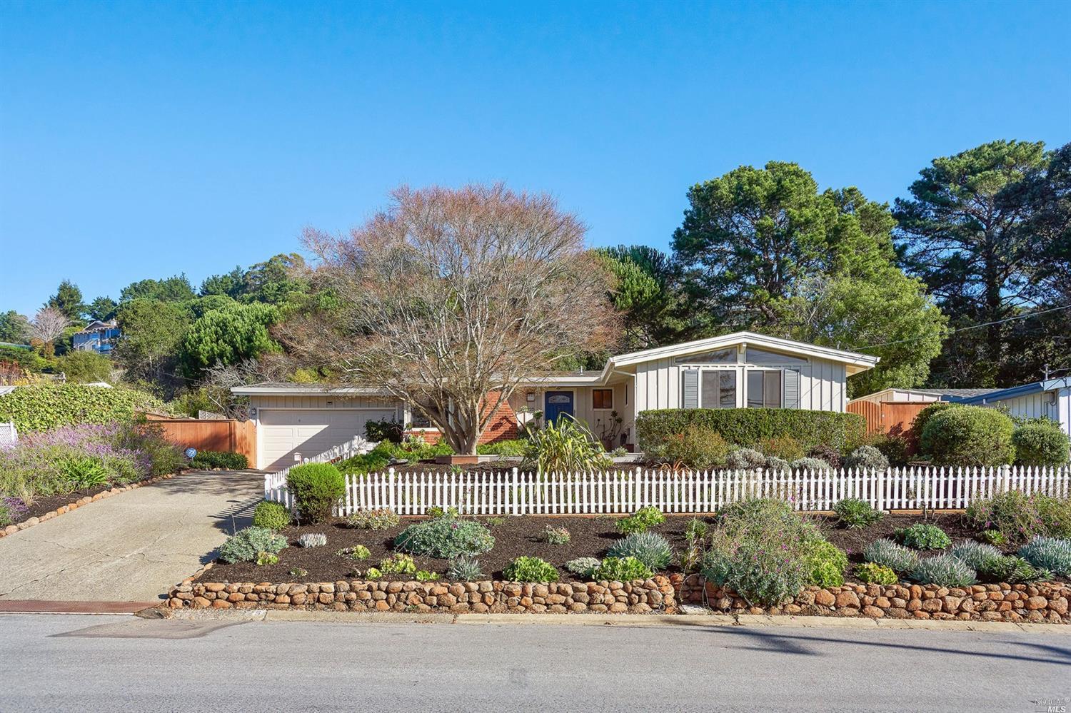 a front view of a house with a garden