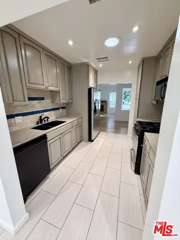 a kitchen with stainless steel appliances a refrigerator sink and stove