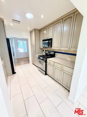 a kitchen with stainless steel appliances a refrigerator sink and microwave