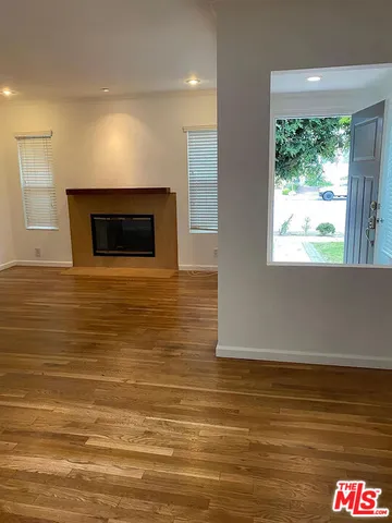 a view of an empty room with a fireplace and a window