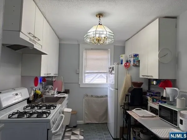 a kitchen with a refrigerator and a stove top oven
