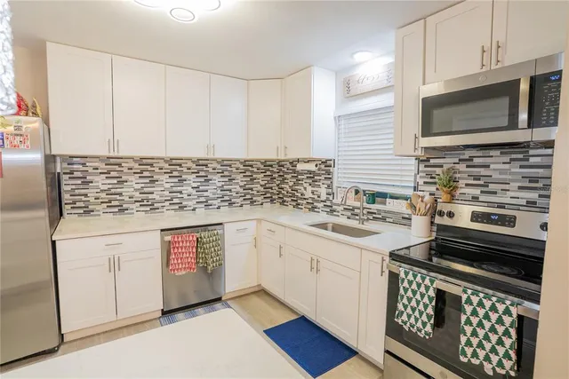 a kitchen with stainless steel appliances a stove a sink and a microwave