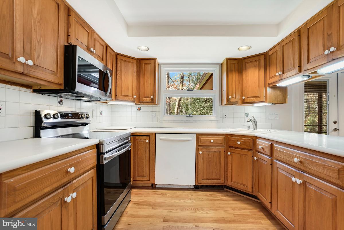 2606 Deerdell Lane Reston, VA 20191 - Photo 11 of 49 a kitchen with stainless steel appliances granite countertop wooden cabinets a stove a sink and a microwave