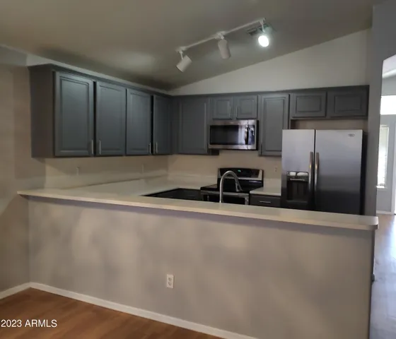 a kitchen with granite countertop a refrigerator and a sink