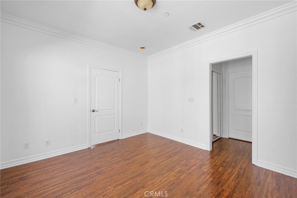 6831 Valmont Street, Unit 1 Tujunga, CA 91042 - Photo 16 of 30 an empty room with wooden floor and windows