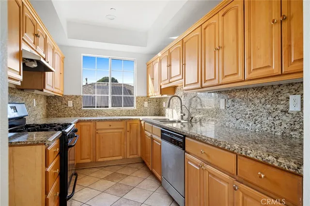 a kitchen with stainless steel appliances granite countertop a stove a sink and a microwave