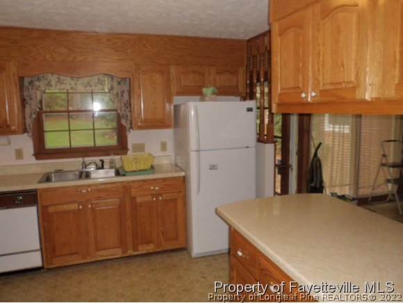 400 Myra Road Raeford, NC 28376 - Photo 12 of 24 a kitchen with a sink a refrigerator and cabinets