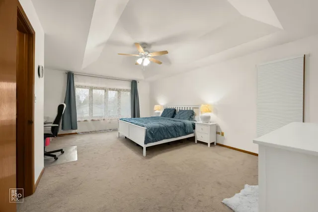 a spacious bedroom with a bed and a chandelier