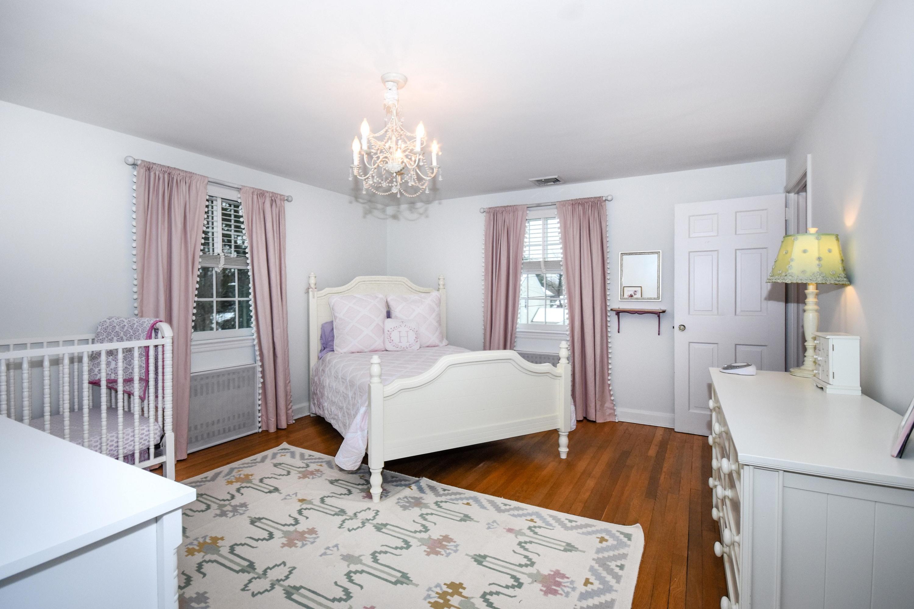 17 Abbey Road Darien, CT 06820 - Photo 15 of 24 a bedroom with a bed and a chandelier