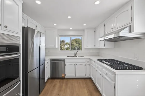 a kitchen with a sink stainless steel appliances and cabinets