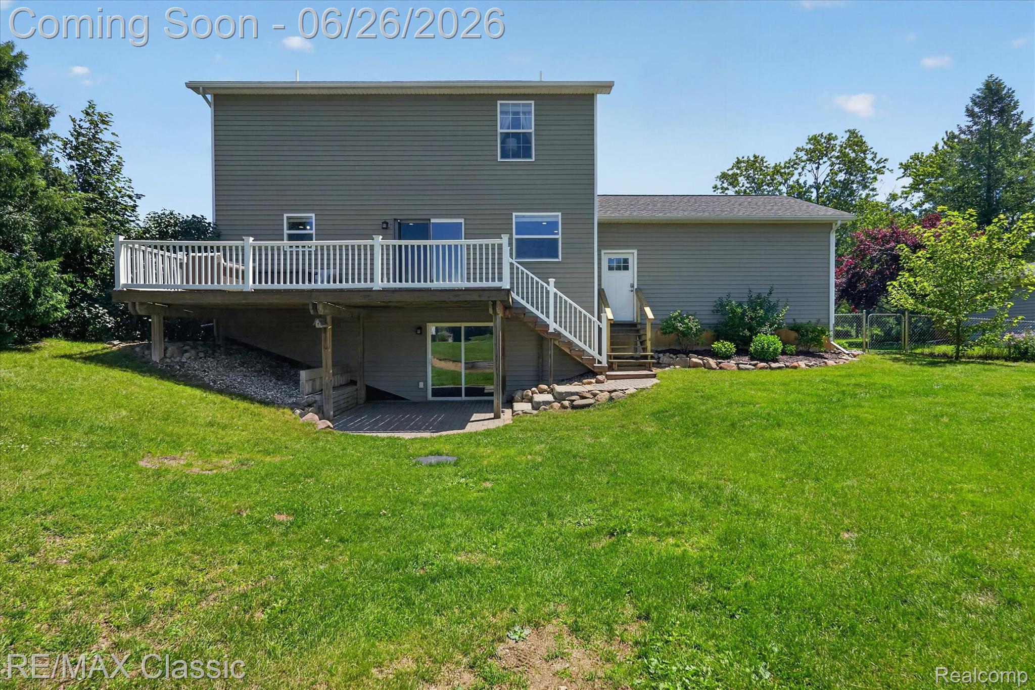 3205 North Milford Road Highland, MI 48357 - Photo 39 of 53 Expansive rear exterior featuring a raised deck with white railing, a lower-level patio, and a walk-out basement entrance