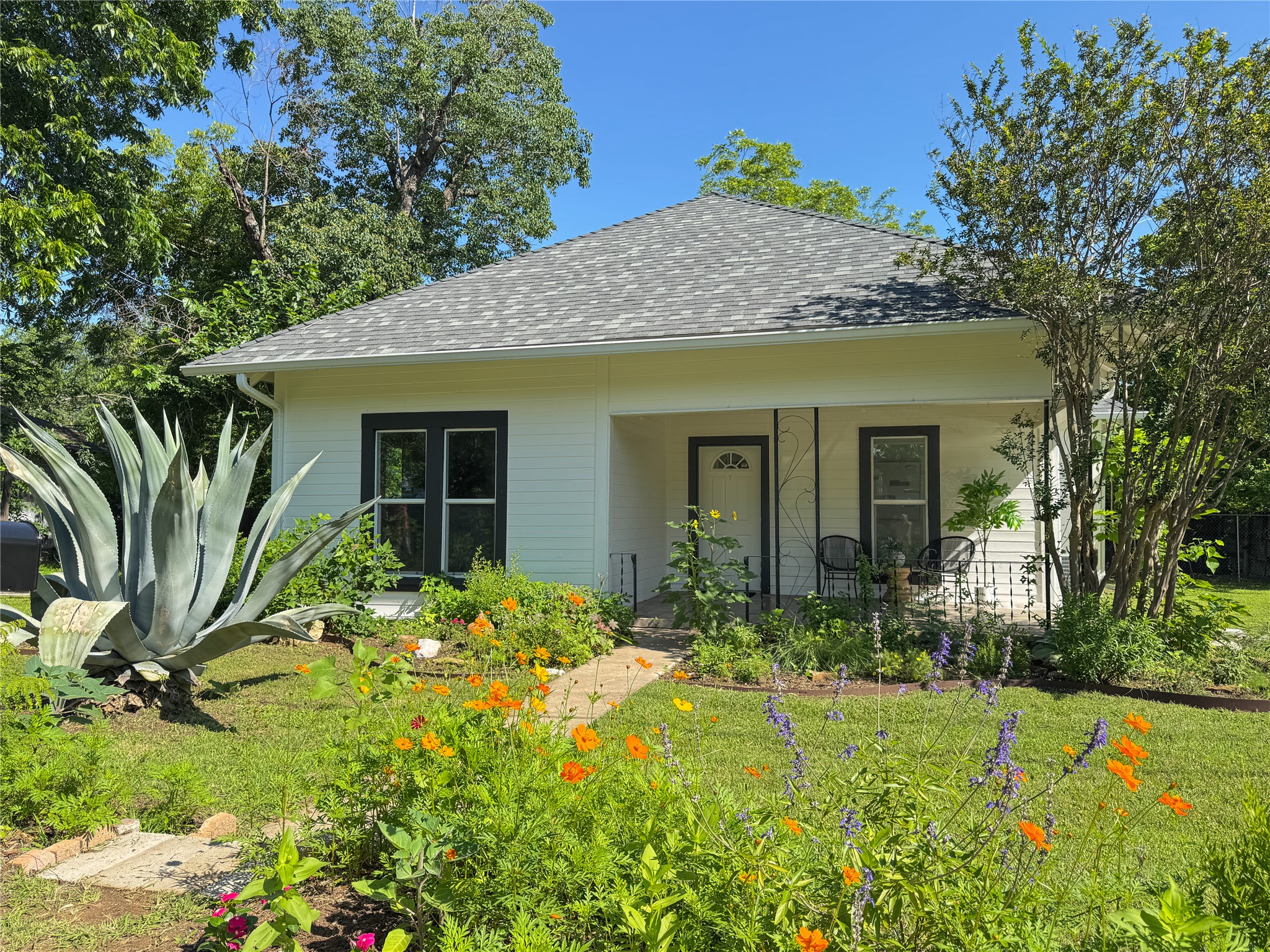 302 East Brenham Street Elgin, TX 78621 - Photo 3 of 38 The front yard greets you with lush native and pollinator plants