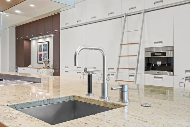 a kitchen with stainless steel appliances kitchen island a refrigerator sink and cabinets