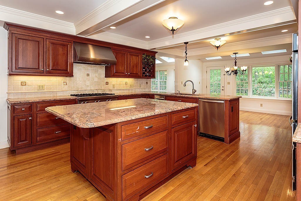 107 Rutledge Road Belmont, MA 02478 - Photo 8 of 16 a kitchen with stainless steel appliances granite countertop wooden floors wooden cabinets and sink