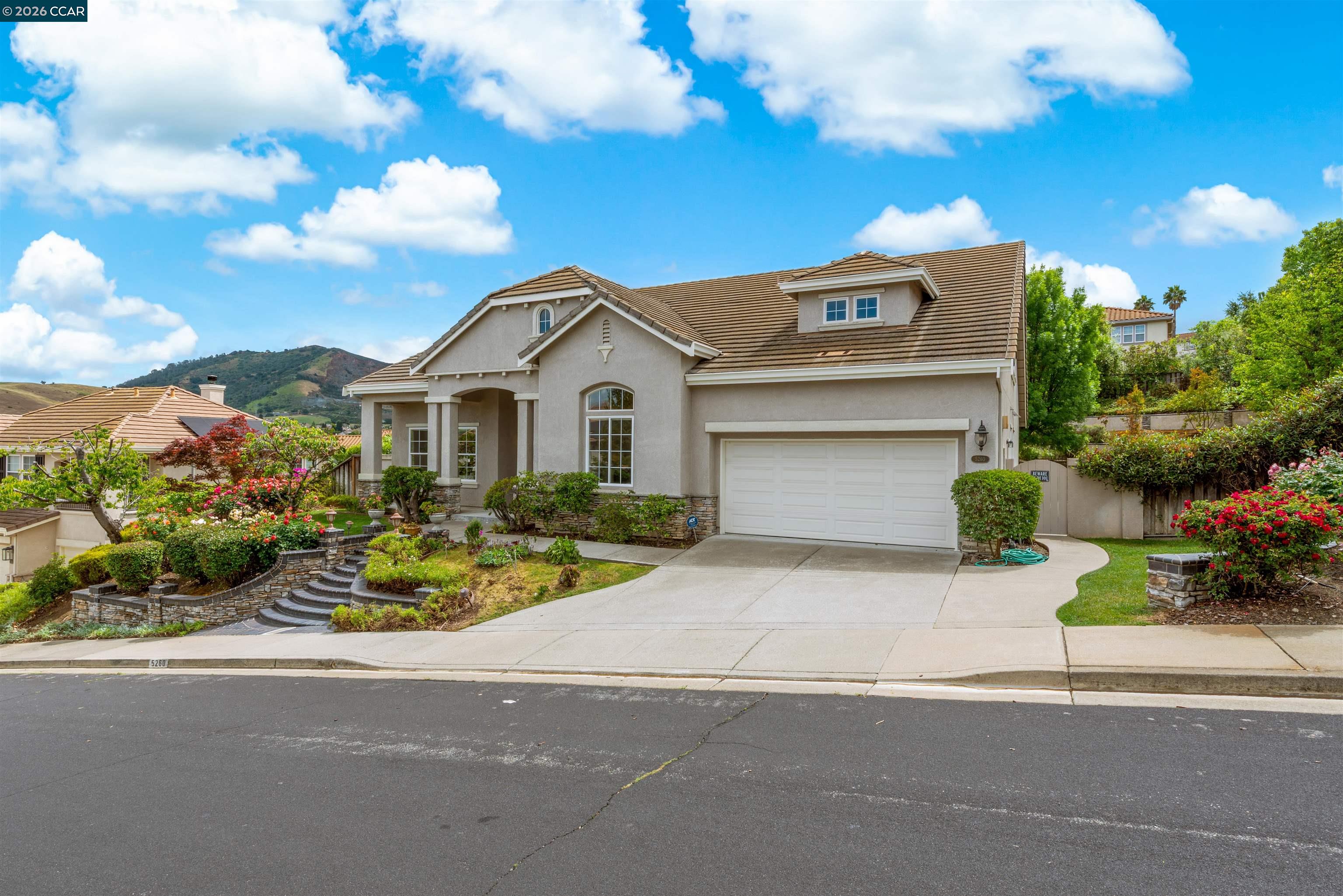 5260 Hiddencrest Court Concord, CA 94521 - Photo 3 of 87 a front view of a house with a garden and mountain view