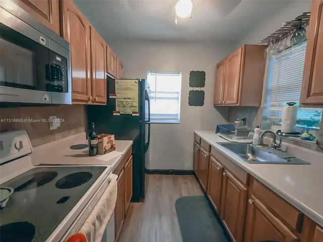 a kitchen with a sink stove top oven and refrigerator