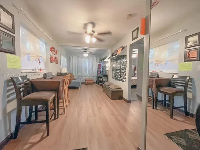 a living room with furniture a flat screen tv and a large window