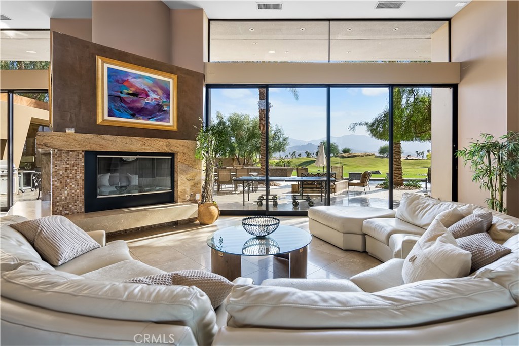 68 Royal St Georges Way Rancho Mirage, CA 92270 - Photo 42 of 75 a living room with furniture large window and a fireplace
